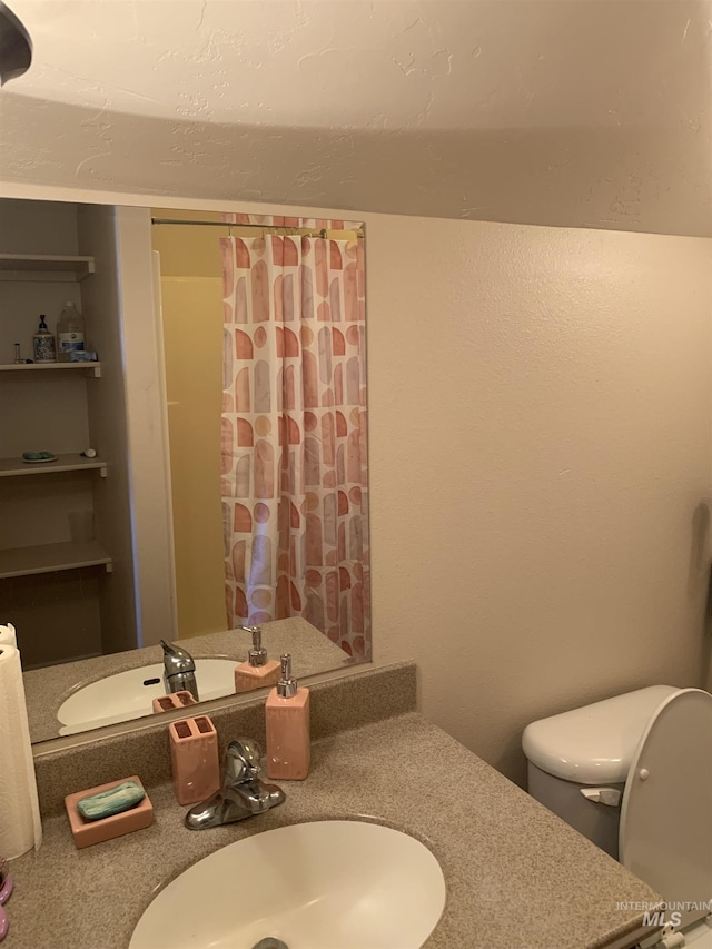 bathroom featuring vanity, curtained shower, and toilet