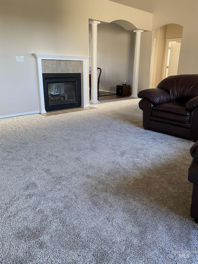 living room featuring carpet floors, a fireplace, and ornate columns