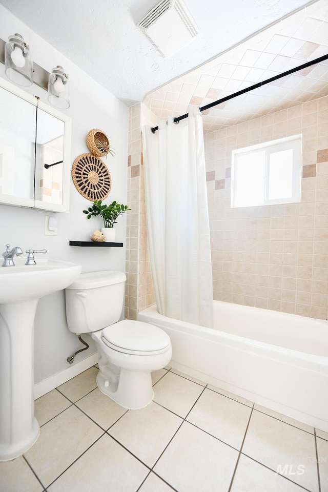 full bathroom with shower / bath combination with curtain, sink, toilet, and tile patterned flooring