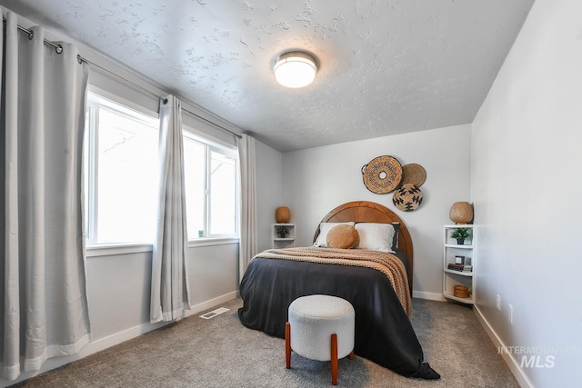 bedroom with carpet floors and a textured ceiling