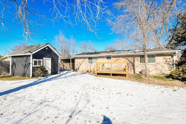 snow covered rear of property with a deck