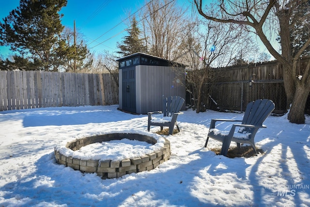 yard layered in snow featuring a storage unit