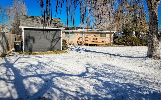 snow covered property featuring a wooden deck