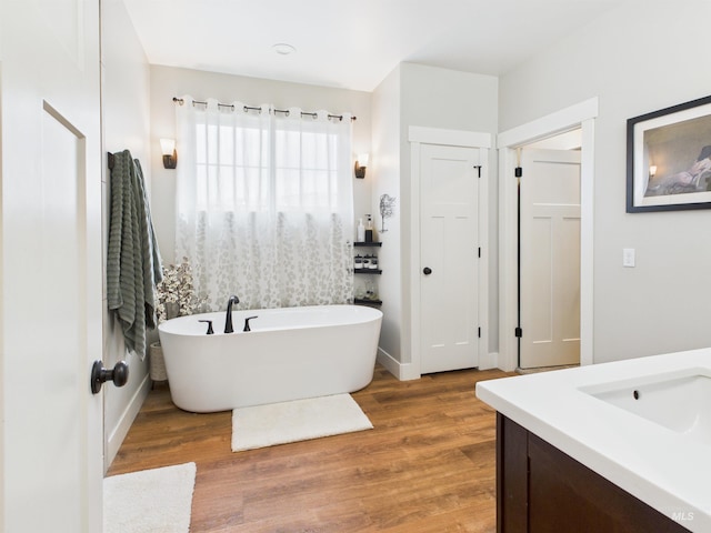 515 School St, Albion, ID 83311 - bathroom featuring vanity, a freestanding bath, and wood finished floors