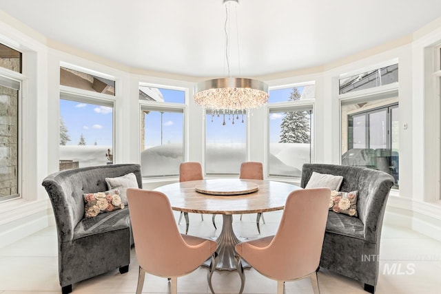 tiled dining room featuring a healthy amount of sunlight and a chandelier