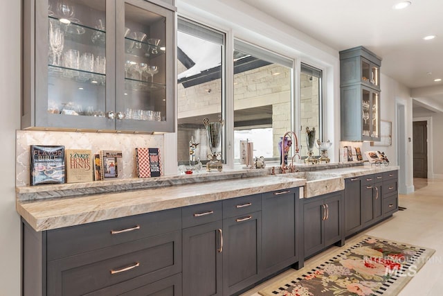 bar with butcher block countertops, tasteful backsplash, and sink