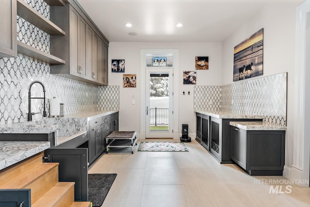 interior space featuring backsplash, light tile floors, and light stone counters