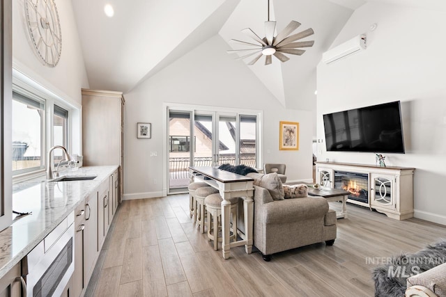 living room with high vaulted ceiling, sink, light hardwood / wood-style flooring, and a wall unit AC