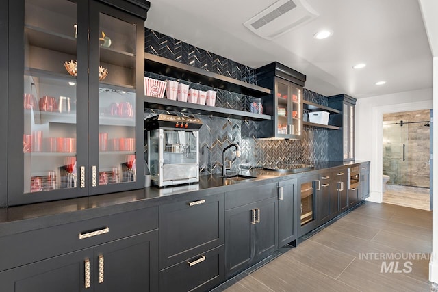 bar with sink, tasteful backsplash, and light tile floors