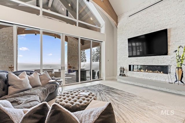 living room with high vaulted ceiling, tile flooring, beamed ceiling, and a fireplace