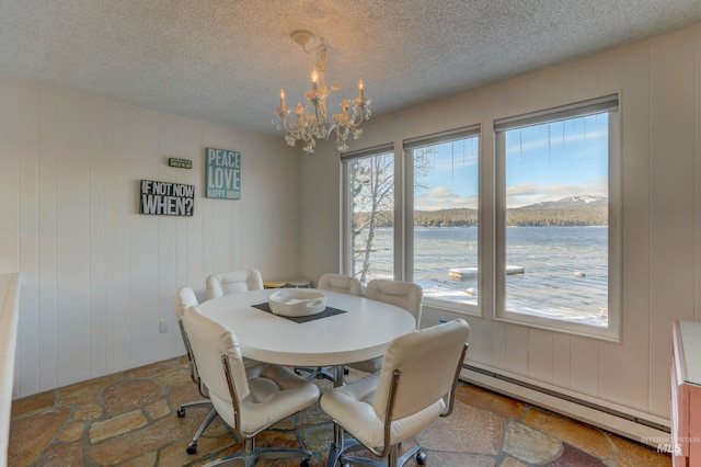 tiled dining area with a textured ceiling, a baseboard radiator, a water view, and a chandelier