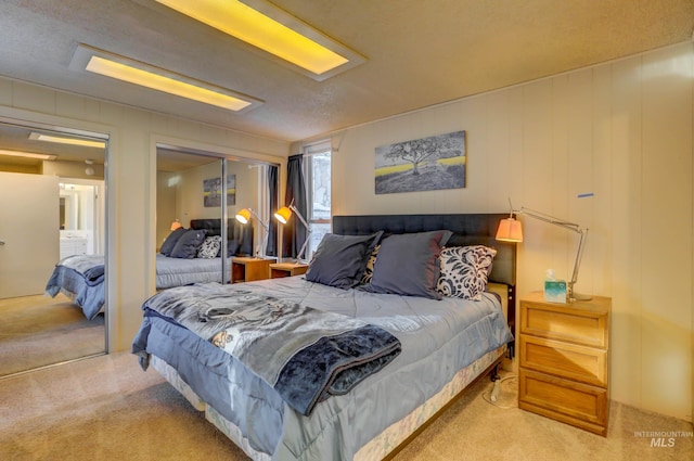 bedroom featuring a closet, a textured ceiling, and light colored carpet