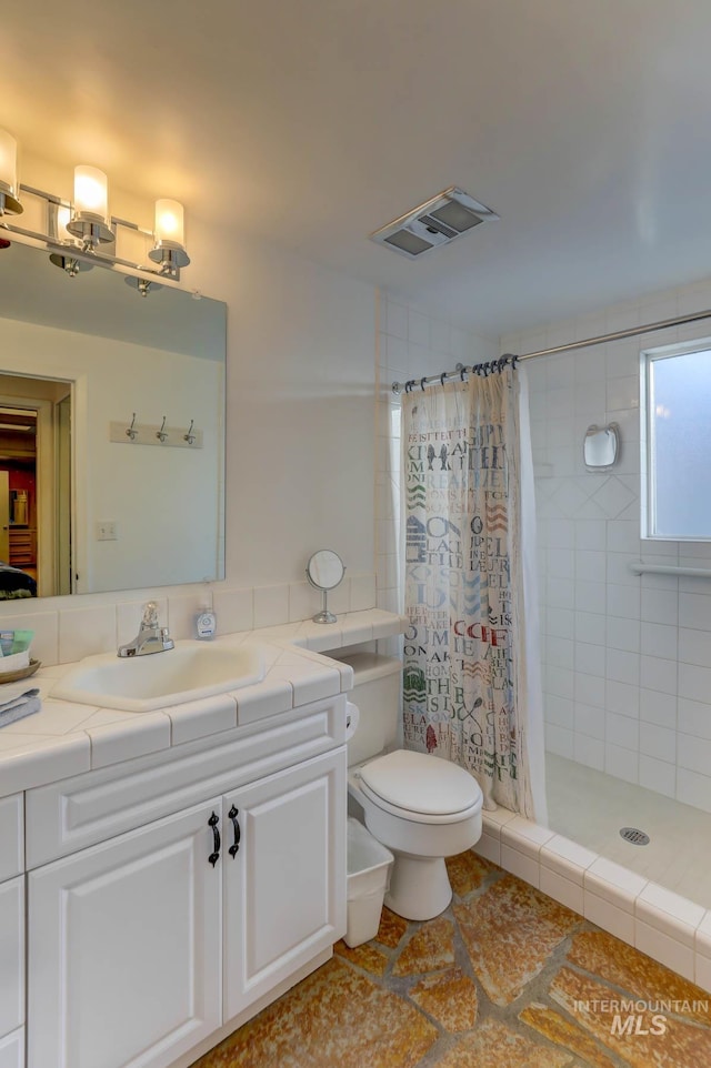 bathroom featuring curtained shower, tile patterned floors, vanity, and toilet