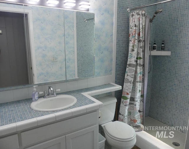 bathroom with walk in shower, toilet, and vanity