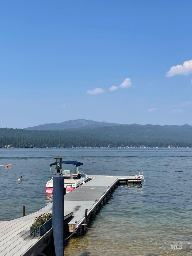 view of dock with a water and mountain view