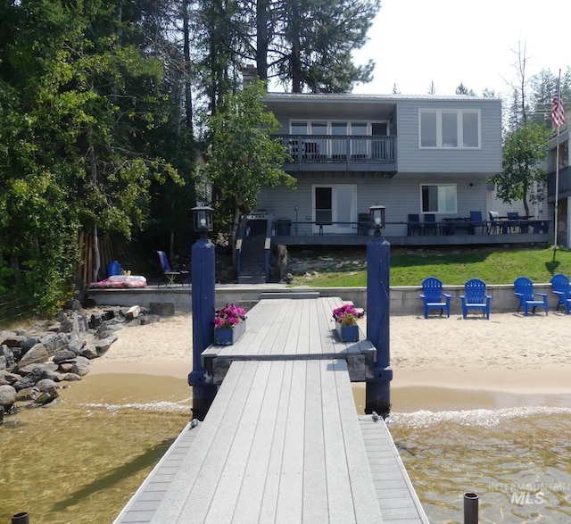 rear view of house with a deck with water view and a balcony