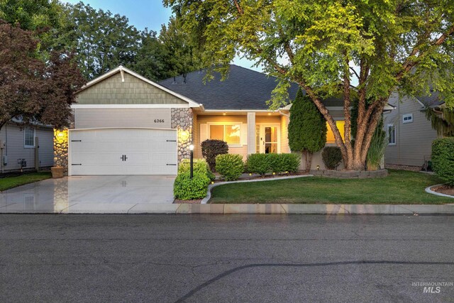 ranch-style home featuring a garage and a front lawn