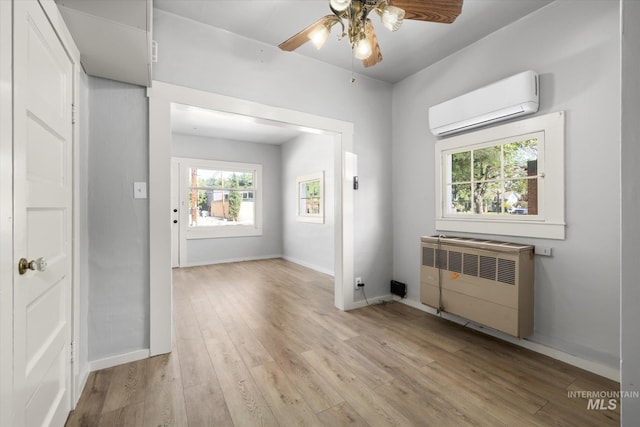 710 N 15th St, Boise, ID 83702 - empty room featuring a wall unit AC, radiator heating unit, light wood finished floors, and a ceiling fan