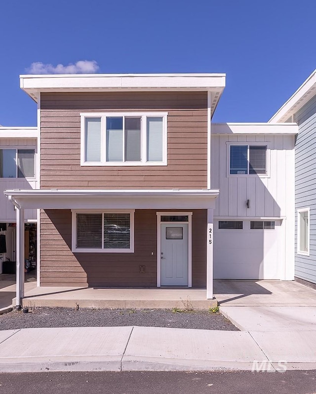 view of front of house featuring covered porch, driveway, board and batten siding, and an attached garage