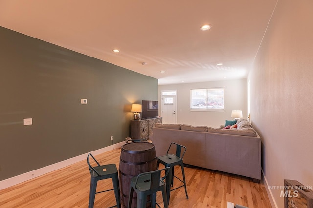 living area with recessed lighting, light wood-type flooring, and baseboards