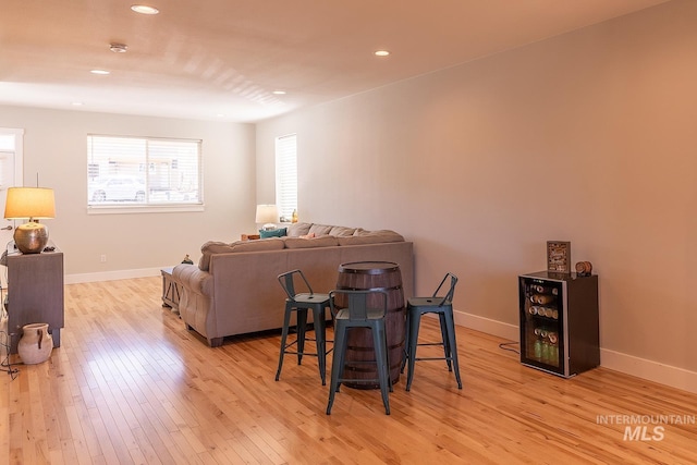 living area with baseboards, recessed lighting, and light wood-style floors