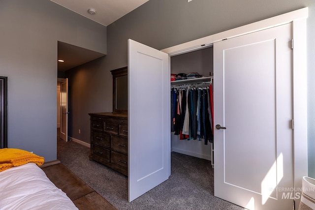 bedroom featuring a closet, dark carpet, and baseboards