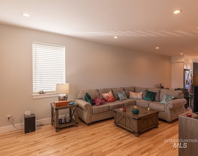 living area with light wood-style flooring, baseboards, and recessed lighting