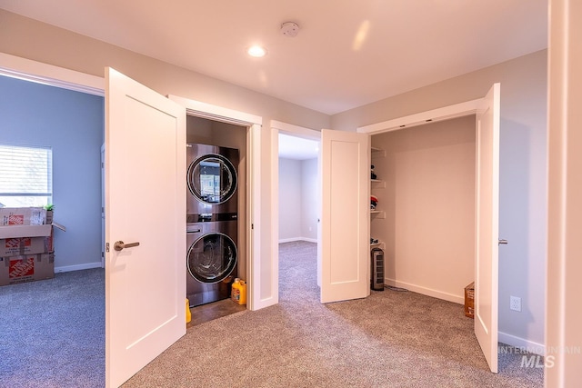 interior space with carpet, stacked washer and clothes dryer, recessed lighting, laundry area, and baseboards