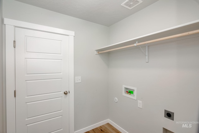 laundry area with hardwood / wood-style floors, hookup for a washing machine, and hookup for an electric dryer