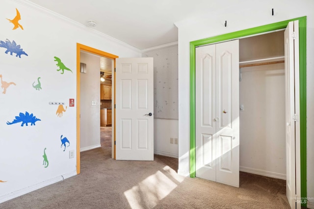 bedroom with baseboards, carpet floors, a closet, and crown molding