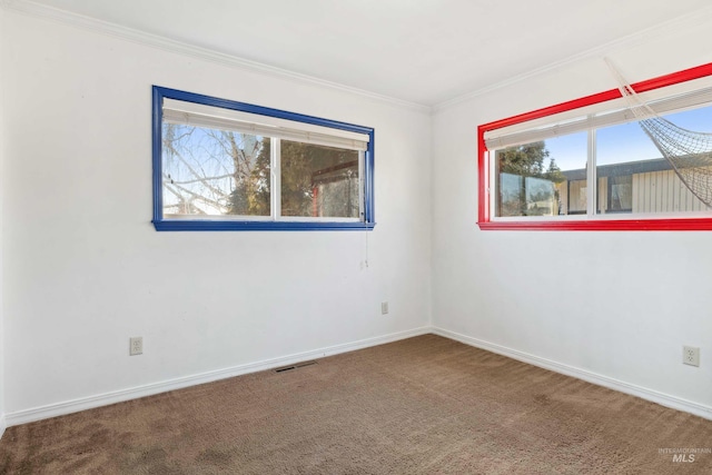 carpeted empty room featuring ornamental molding, visible vents, and baseboards