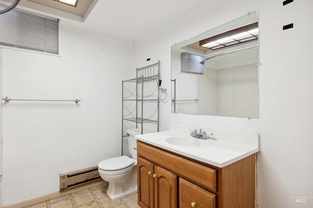 bathroom with a baseboard radiator, vanity, toilet, and tile patterned floors