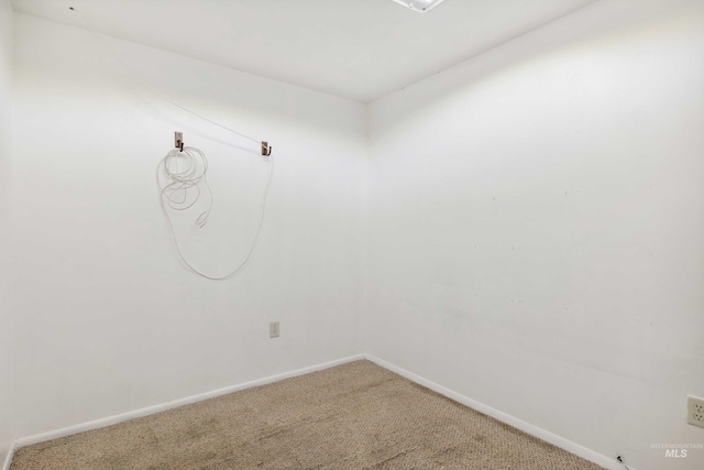 spare room featuring carpet and baseboards