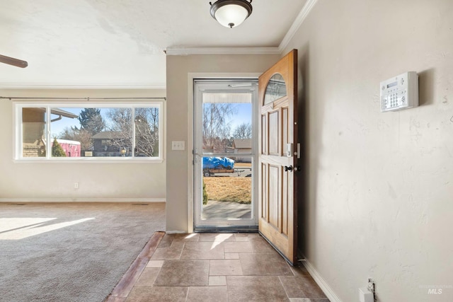 doorway with baseboards, carpet floors, stone tile floors, and crown molding