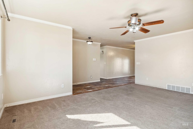 carpeted spare room featuring a ceiling fan, visible vents, crown molding, and baseboards