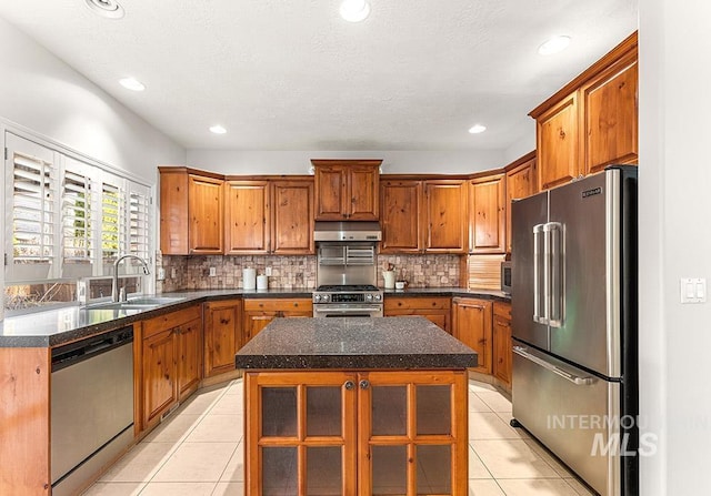 1472 N Watson Ave, Eagle, ID 83616 - kitchen featuring appliances with stainless steel finishes, a sink, under cabinet range hood, light tile patterned floors, and decorative backsplash