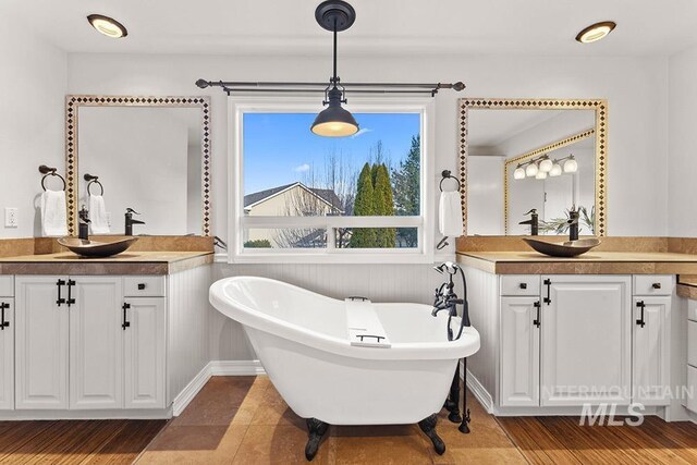 1472 N Watson Ave, Eagle, ID 83616 - bathroom featuring two vanities, a freestanding bath, and wood finished floors