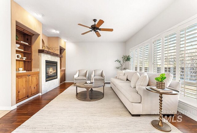 1472 N Watson Ave, Eagle, ID 83616 - living room featuring a ceiling fan, dark wood finished floors, a tiled fireplace, baseboards, and built in features