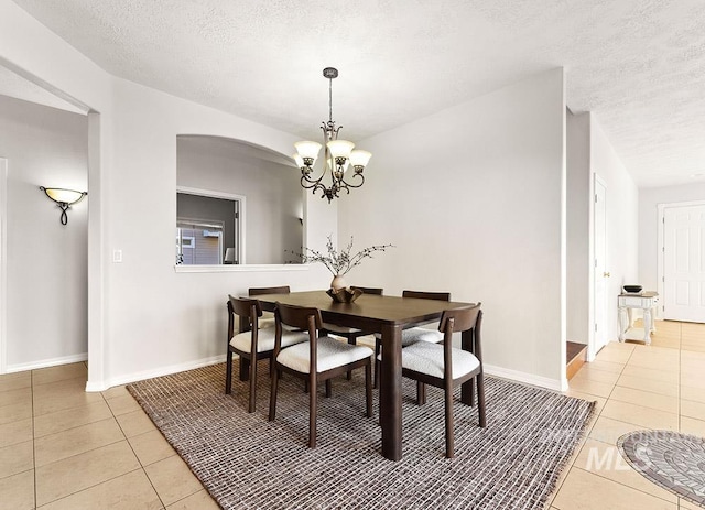 1472 N Watson Ave, Eagle, ID 83616 - dining room featuring light tile patterned floors, arched walkways, baseboards, a chandelier, and a textured ceiling