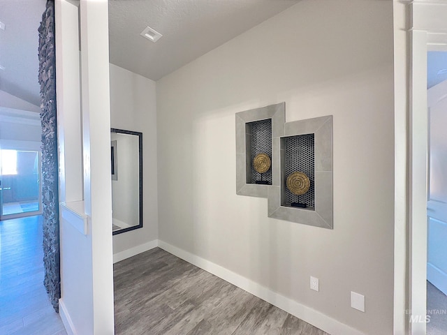 hall featuring hardwood / wood-style flooring and a textured ceiling