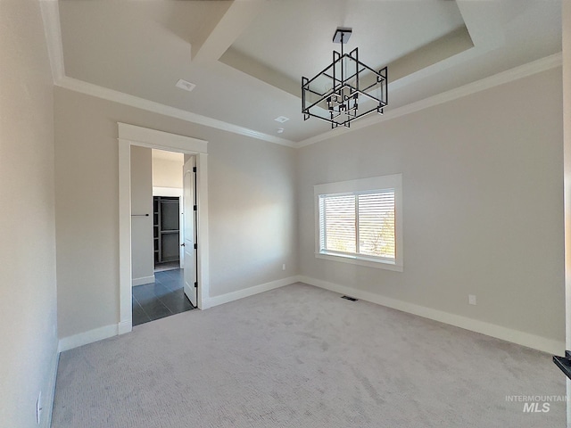 carpeted empty room featuring a raised ceiling, a notable chandelier, and ornamental molding