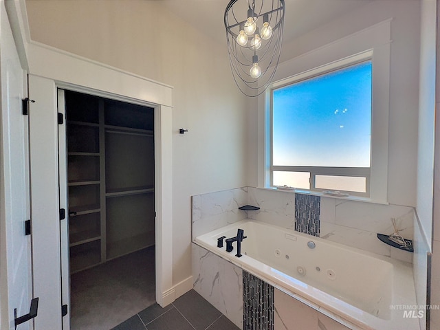 bathroom featuring tile patterned floors, a relaxing tiled tub, and a chandelier