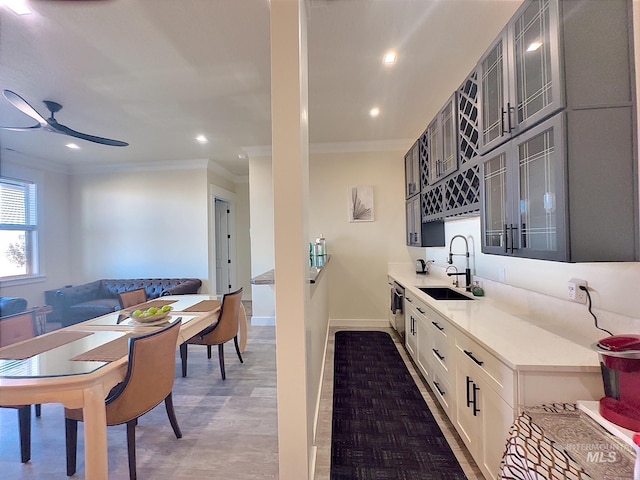 kitchen with ceiling fan, sink, dark hardwood / wood-style flooring, white cabinets, and ornamental molding