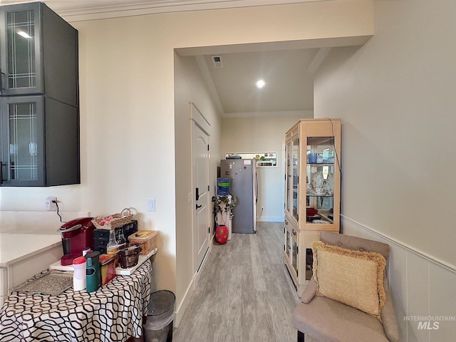 kitchen with light hardwood / wood-style flooring and crown molding