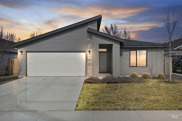 view of front of property featuring a garage, concrete driveway, and a front yard