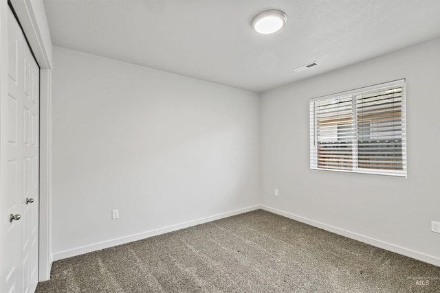 unfurnished bedroom with a closet, visible vents, baseboards, and carpet