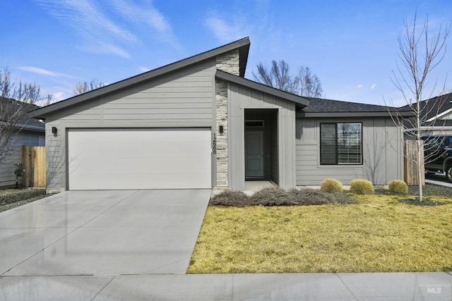 mid-century inspired home with a front lawn, an attached garage, and driveway