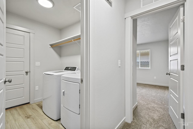 laundry room featuring visible vents, light carpet, independent washer and dryer, baseboards, and laundry area