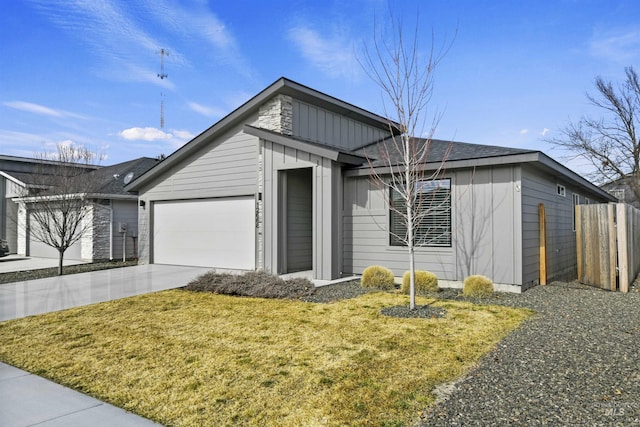 mid-century modern home featuring board and batten siding, fence, a front yard, driveway, and an attached garage