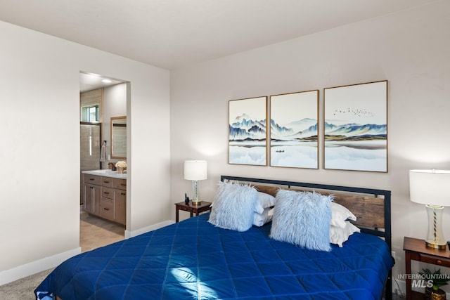 bedroom featuring light carpet and connected bathroom